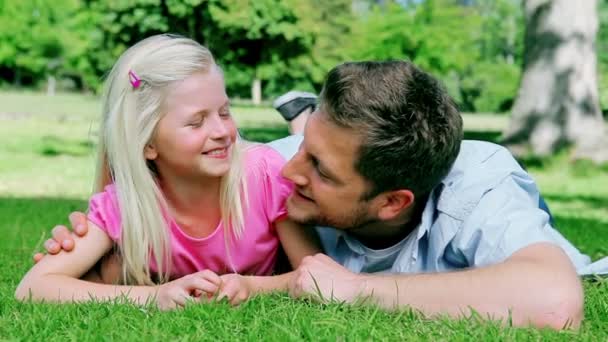 Fadern talar till hans leende dotter innan titta på kameran och ler — Stockvideo