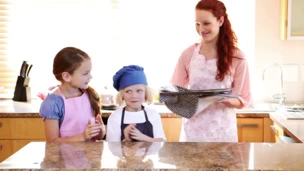 Madre sonriente dando galletas a sus hijos — Vídeo de stock