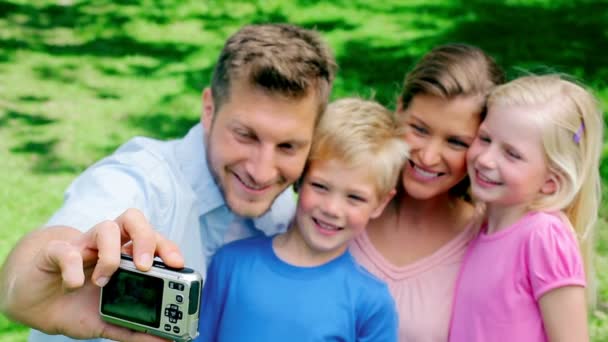 Pai tira uma foto de si mesmo e de sua família antes de olhar para a galeria de fotos na câmera — Vídeo de Stock