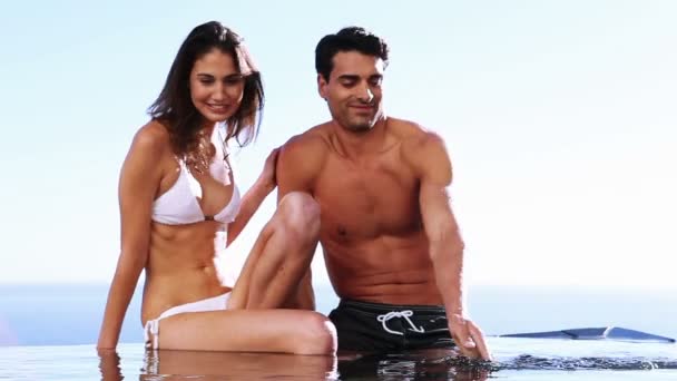 Couple souriant assis dans une piscine — Video