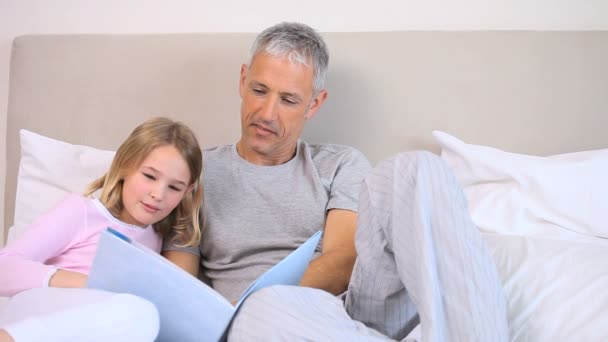 Vader en dochter die een boek lezen — Stockvideo