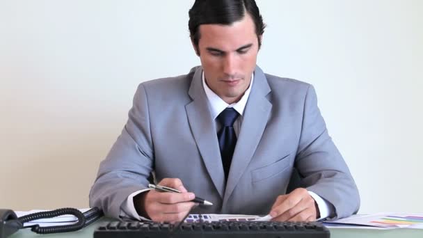 Серьезный бизнесмен, работающий над графиками — стоковое видео