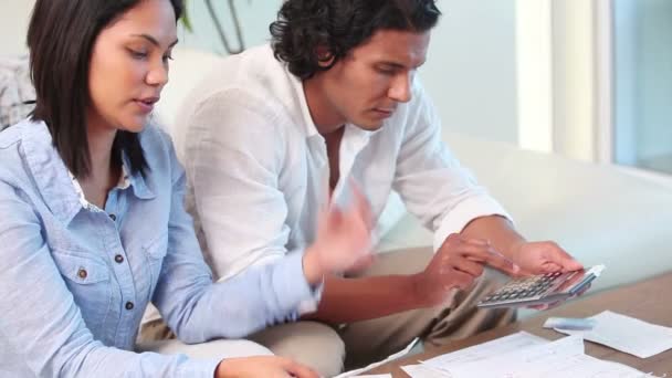 Молода пара з паперовою роботою з ноутбуком — стокове відео
