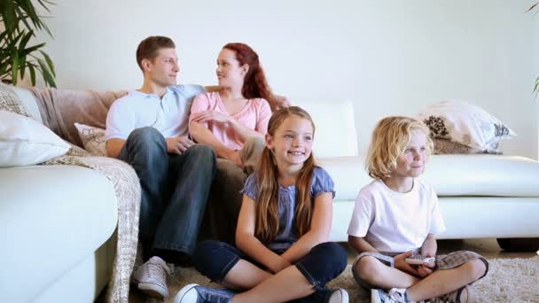 Lächelnde Familie vor dem Fernseher — Stockvideo