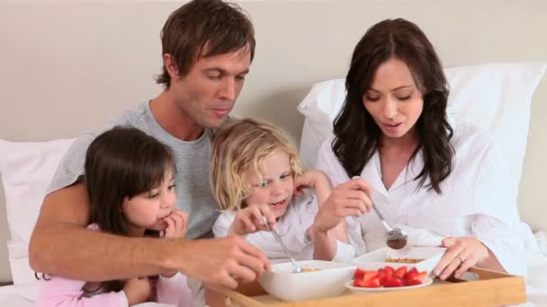 Sonriente familia comiendo su desayuno — Vídeo de stock