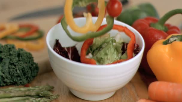 Gemüse fällt in Superzeitlupe in Schüssel — Stockvideo
