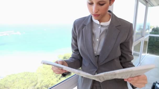 Uma mulher de negócios lendo um jornal — Vídeo de Stock