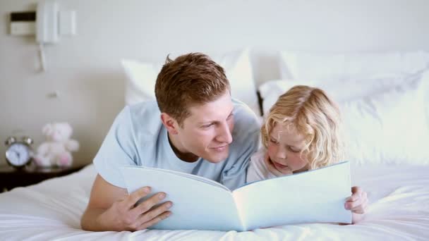 Bonito criança lendo um livro para seu pai — Vídeo de Stock