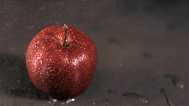 Water sprayed on apple in super slow motion — Stock Video