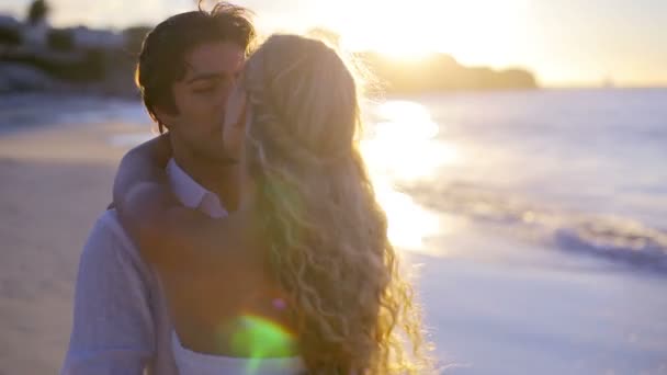 Pareja girando y besándose durante el atardecer en la playa — Vídeo de stock