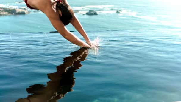 Женщина ныряет в воду в замедленной съемке — стоковое видео