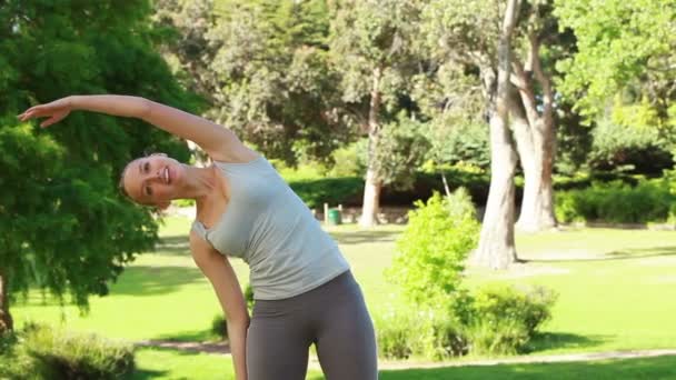 Uma mulher estende os braços antes de ir treinar — Vídeo de Stock