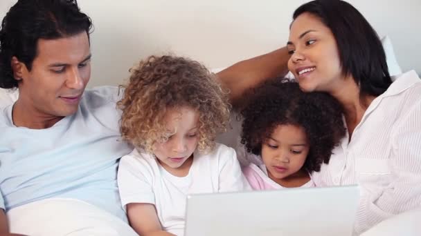 Familia con portátil en su cama — Vídeos de Stock