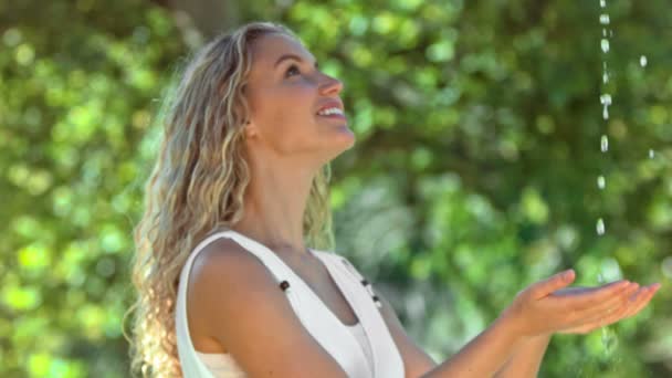 Happy woman in slow motion catching water — Stock Video