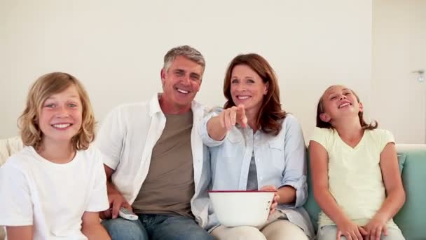 Familie lachen terwijl het letten van op televisie — Stockvideo