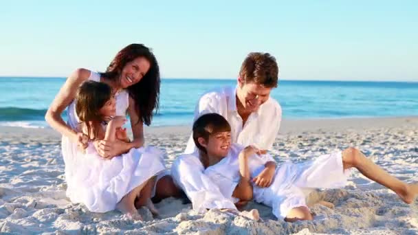 Familie sitzt im Sand — Stockvideo