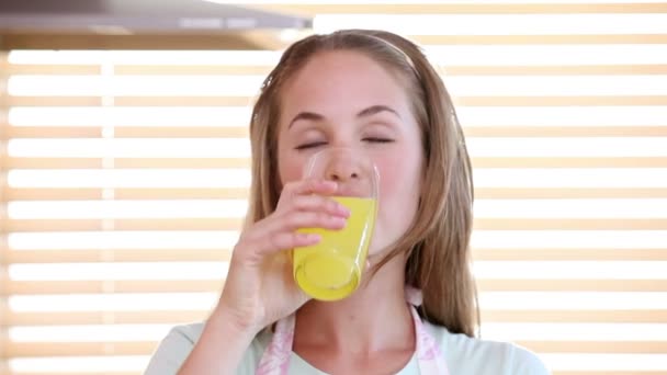 Улыбающаяся женщина пьет апельсиновый сок — стоковое видео
