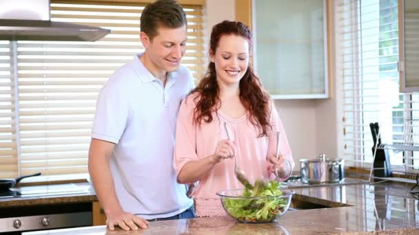 Mujer sonriente mezclando una ensalada — Vídeos de Stock