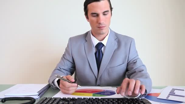 Серьезный бизнесмен, работающий над документами — стоковое видео