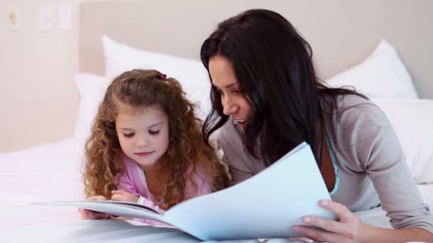 Woman reading a story for her daughter — Stock Video