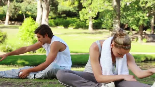 Una pareja se estira y se prepara para el entrenamiento — Vídeos de Stock