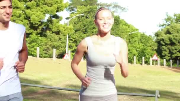 Lachende paar jog samen als tijd is verstreken en ze zijn verdere op de weg — Stockvideo