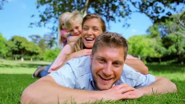 Familie lacht, als sie übereinander liegen — Stockvideo