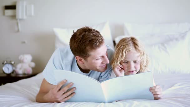 Vater und Sohn lesen gemeinsam ein Buch — Stockvideo