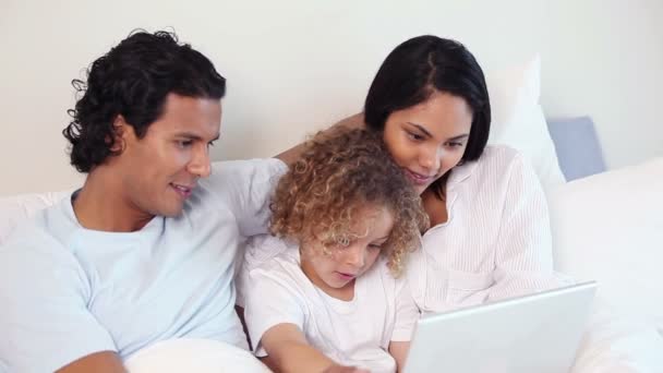 Famiglia in un letto con un computer portatile — Video Stock