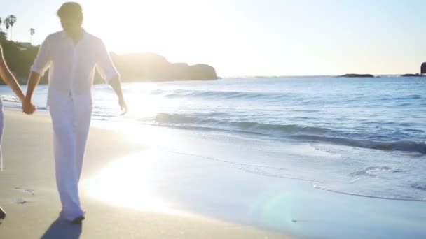 Paar hand in hand terwijl ze langs het strand lopen — Stockvideo