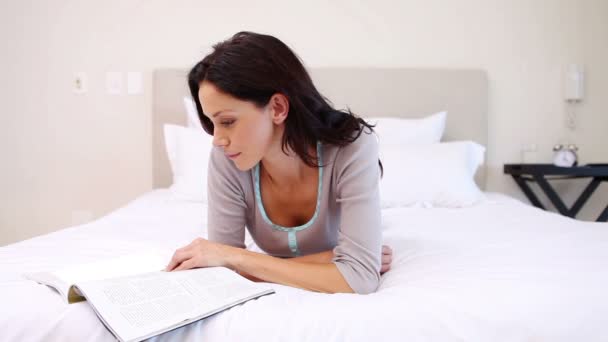 Mujer leyendo en su cama — Vídeo de stock