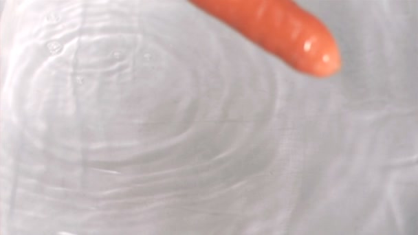 Carrot falling into water in super slow motion — Stock Video