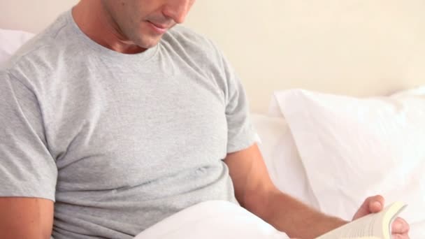 Hombre sonriente leyendo un libro — Vídeos de Stock