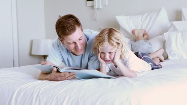 Enfant lisant un livre avec son père — Video