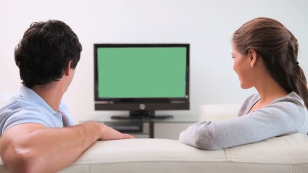 Пара, которая смотрит на экран телевизора — стоковое видео