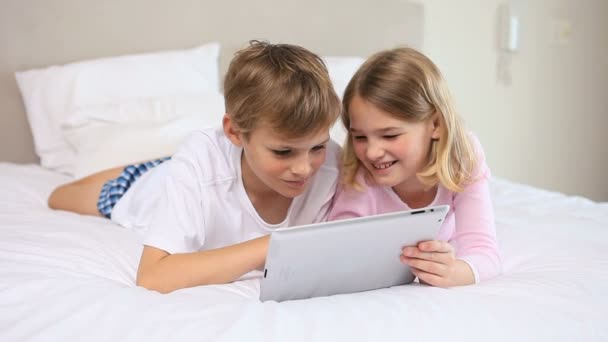 Irmãos alegres usando um computador tablet — Vídeo de Stock