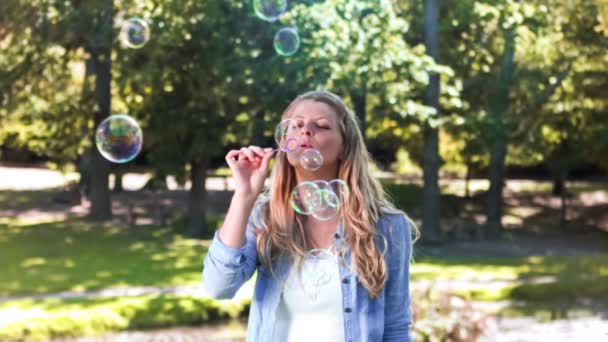 Blondýnka v pomalém pohybu vyfukuje bubliny — Stock video