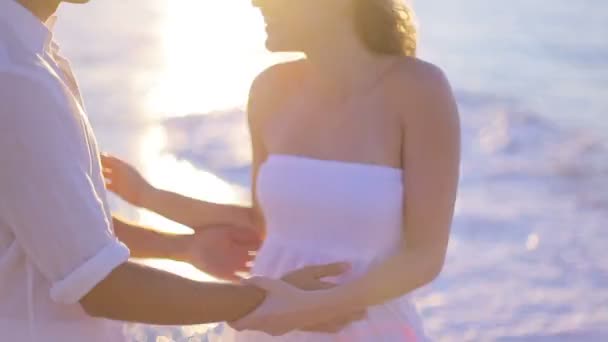 Par kyssas under solnedgången på stranden och promenader mot havet efteråt — Stockvideo