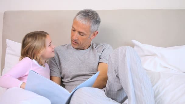 彼女の父親と一緒に本を読んで笑顔の女の子 — ストック動画