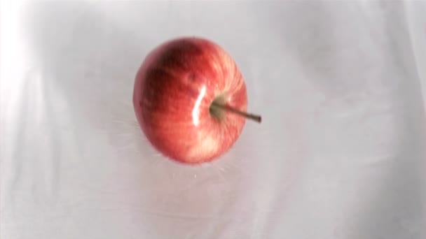 Яблоко падает в воду в супер замедленной съемке — стоковое видео