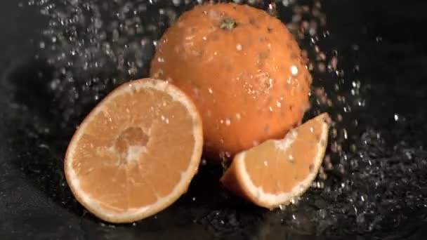 Water raining in super slow motion on oranges — Stock Video