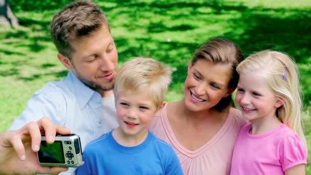 Familie posiert für ein Foto, bevor sie sich die Fotogalerie in der Kamera ansieht — Stockvideo