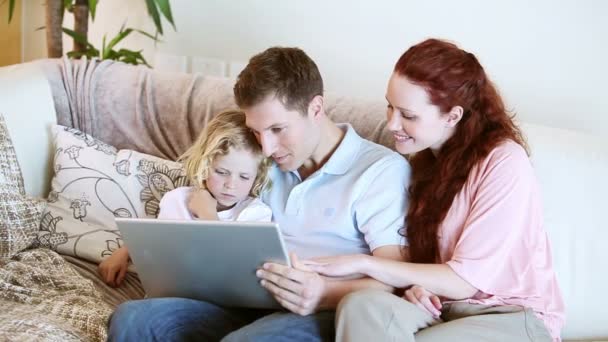 Familia sentada junto con un ordenador portátil — Vídeos de Stock