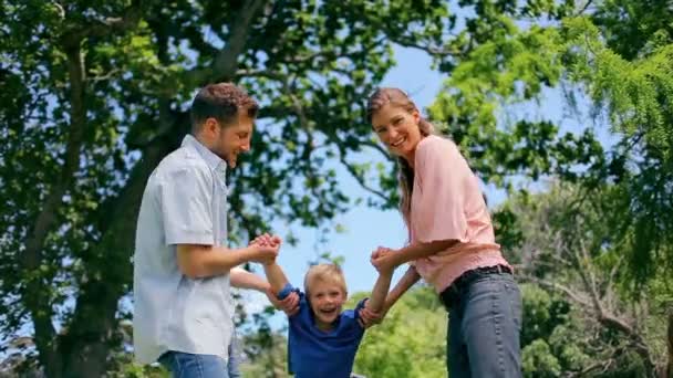 Hombre y mujer balanceando a un niño — Vídeo de stock