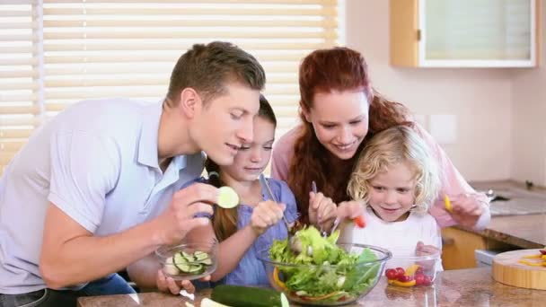 Família fazendo uma salada com legumes — Vídeo de Stock