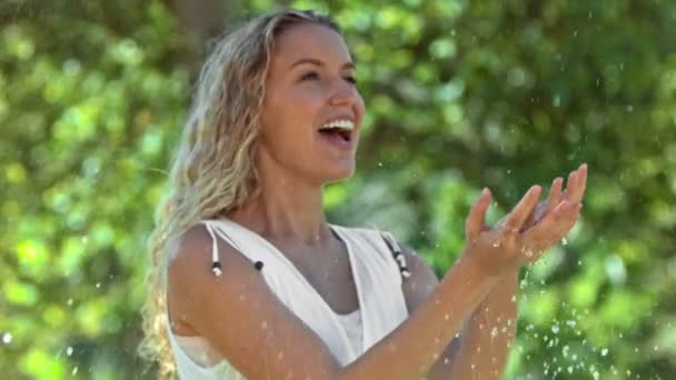 Blonde woman in slow motion catching water — Stock Video