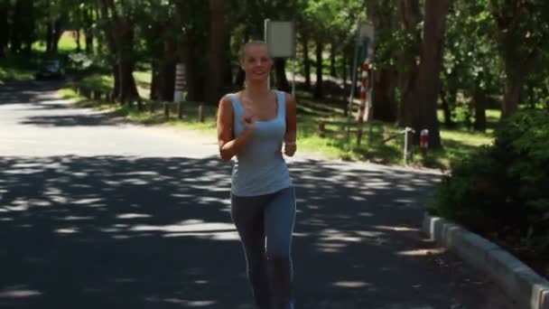 Vrouw joggen in de straat als een auto rijdt achter haar — Stockvideo