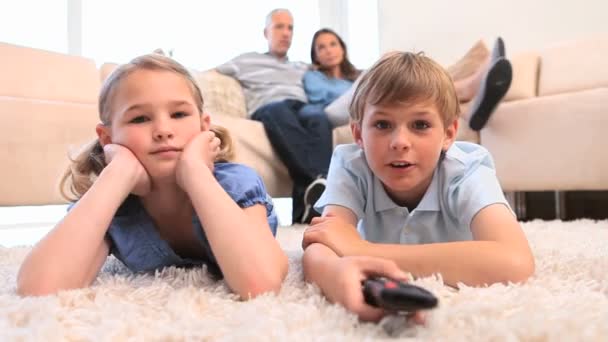 Niños viendo la televisión con sus padres — Vídeo de stock