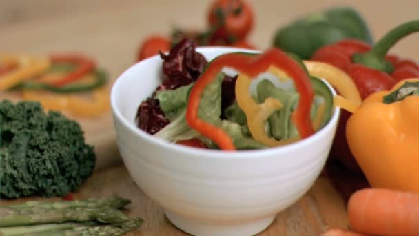 Peppers falling into a salad in super slow motion — Wideo stockowe