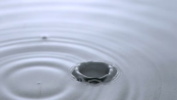Stor droppe faller i super slow motion på vatten — Stockvideo